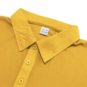 Close-up of yellow waffle knit polo shirt showing collar detail and button placket