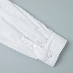 Detailed macro view of white shirt cuffs featuring pleated texture and fabric buttons