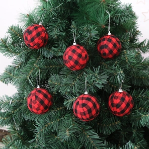 Set of 6 red and black buffalo plaid fabric Christmas ornaments hanging on a green tree