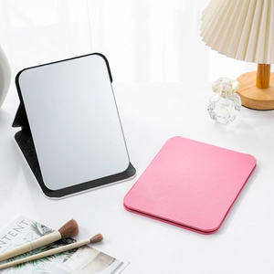 Chic foldable PU leather travel makeup mirrors in black and pink on a stylish desk