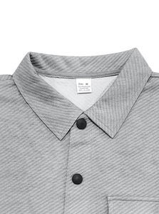 Close-up of light grey jacquard polo shirt collar with detailed fabric composition tag