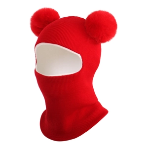 Detail of red knit baby balaclava featuring double pompoms and thick thermal lining