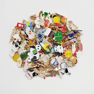 Collection of colorful cartoon enamel pins featuring animals and food on white background