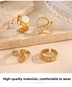 Macro detail of gold-plated rings with white enamel and Forever engraving on stone base