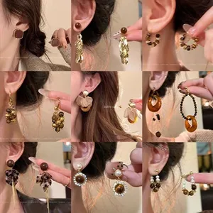 Collection of brown resin earrings with pearls and leopard patterns in a 9-grid layout