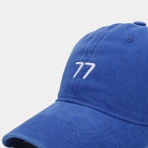 Détail de la broderie blanche 77 sur une casquette de baseball en coton bleu vintage