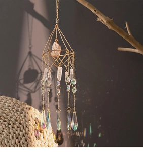 Close-up of geometric crystal suncatcher with golden prisms and rainbow droplets