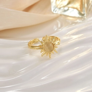 Macro detail of sunburst opal open ring on white waves and champagne silk texture