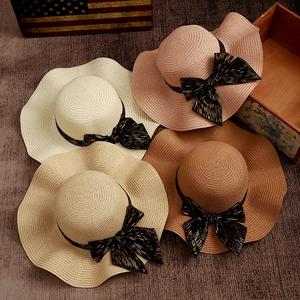 Wide brim straw sun hats with wavy edges and black ribbon bows in four stylish colors