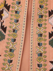 Detailed close-up of ethnic geometric embroidery on peach-pink bohemian vest for women