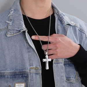 Gros plan d'un collier pendentif double croix en acier inoxydable argenté sur un mannequin