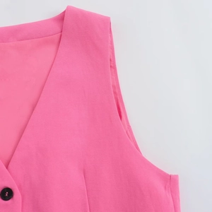 Gros plan d'un gilet rose vif à col en V montrant les boutons et la texture du tissu lisse