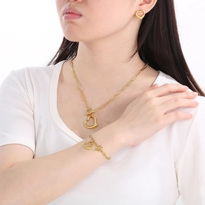 Detail view of gold heart jewelry set with paperclip chains and toggle clasps