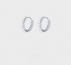 Macro shot of S925 sterling silver hoop earrings featuring eight inlaid white pearls
