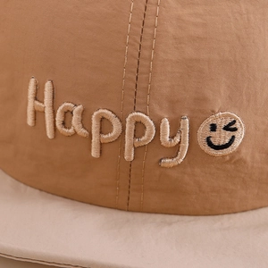 Gros plan du chapeau bébé avec broderie Happy et smiley sur un tissu respirant doux