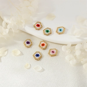 Colorful handmade evil eye seed bead charms for DIY jewelry making on white silk