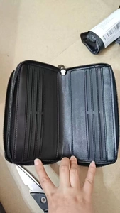 Detail showing multiple card slots and interior compartments of the black leather clutch bag