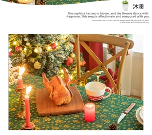 Detail of forest green Christmas tablecloth with gold snowflake print and holiday decor