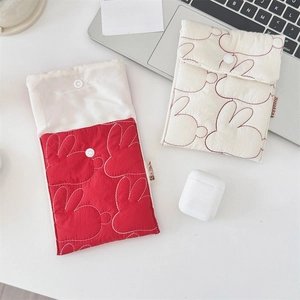 Detail view of quilted cotton pouches with rabbit embroidery and white snap button closure