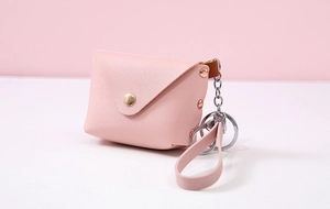 Close-up of mini pink PU leather coin purse with rose gold keychain and metal ring