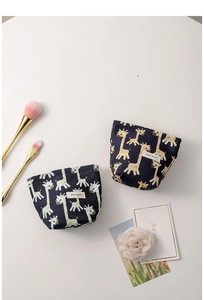 Detailed flat lay of cute giraffe pattern jacquard makeup bags with makeup brushes