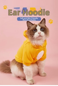 Detail of yellow fleece pet hoodie with soft hood and white circular patch for cats