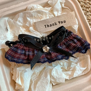 Close-up of vintage plaid fabric hair clip with a black ribbon bow and a star-shaped crystal