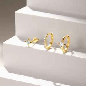Detail of gold-plated star stud and zircon earrings set on a stepped display