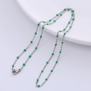 Detail of silver O-chain necklace featuring green epoxy beads and a lobster clasp