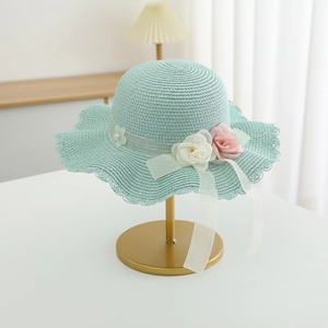 Detail of mint green straw hat with 3D floral accents and wavy brim for girls