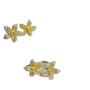Elegant gold flower jewelry set featuring crystal pave stud earrings and matching ring