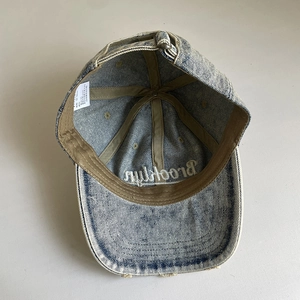 Internal view of washed denim baseball cap with Brooklyn embroidery and adjustable strap