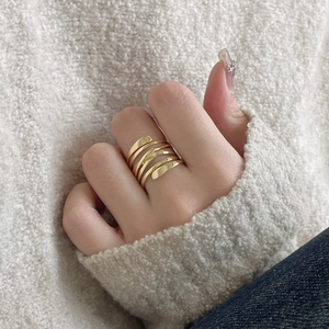 Detailed view of layered gold wrap ring on a model wearing a cozy cream knit sweater