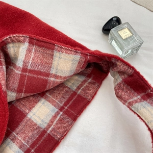 Detail of red wool tote bag with classic plaid lining and soft plush texture finish