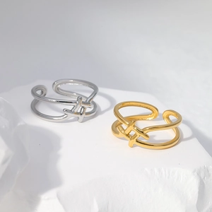 Detail of adjustable double-layer gold and silver rings on a textured white stone
