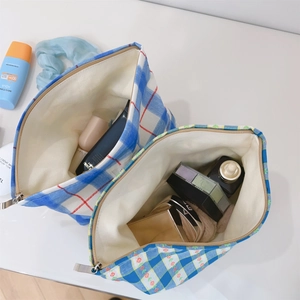 Detail view of large capacity fabric makeup bags with plaid and floral patterns and zippers