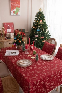 Macro detail of red Christmas jacquard tablecloth with festive bells and tassel edge
