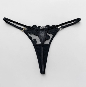Detailed view of black velvet flower lace thong with gold metal ring accents and thin straps