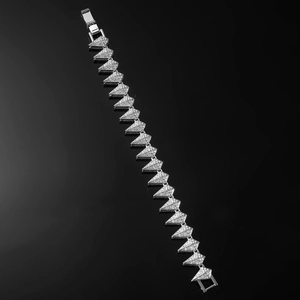 Detailed close-up of iced-out silver cuban chain bracelet with geometric links on black background