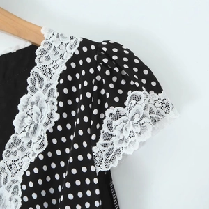 Robe rétro noire à pois pour femmes avec détails délicats de dentelle blanche