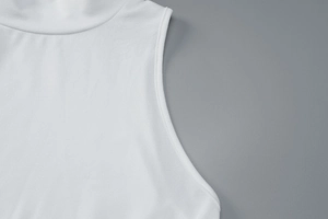 Detail shot of the stand collar and armhole stitching on a white sleeveless dress