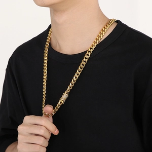 Close-up of gold iced-out Cuban link chain worn by male model on a black t-shirt