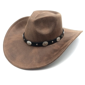 Detailed texture of brown woven cowboy hat with black decorative strap and metal studs