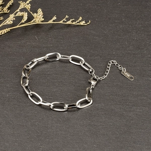 Close-up of paperclip link bracelet in steel finish with K18 engraved metal tag