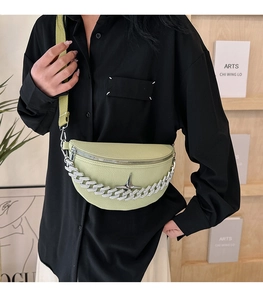 Detail of light green crescent crossbody bag with chunky silver chain and star buckle