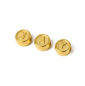 Detailed macro shot of gold plated acrylic letter beads J A Y for DIY jewelry making