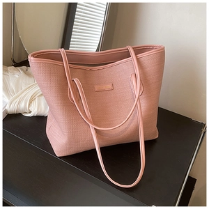 Detailed macro view of the dusty pink tote bag with elegant cross-grain texture and golden logo