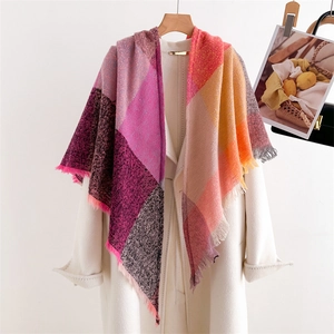 Close-up of colorful checkered scarf with soft fringe detail on a white coat