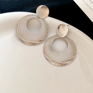 Détail des boucles d'oreilles créoles rondes argentées avec finition métal texturée