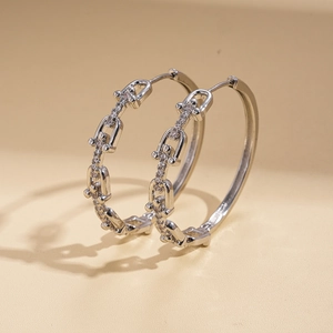 Detailed view of silver chain earrings plated in 18K gold featuring sparkling zircon stones